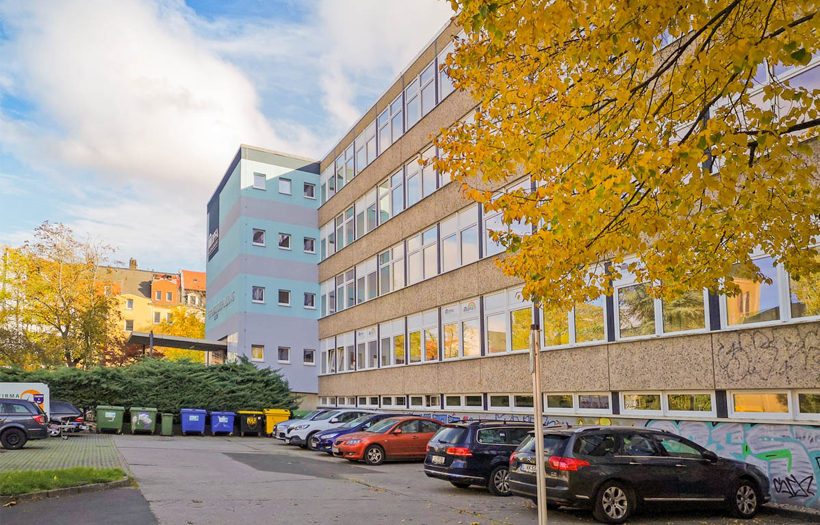 Die Schule der DPFA ist ein hellblaues Gebäude umrin
